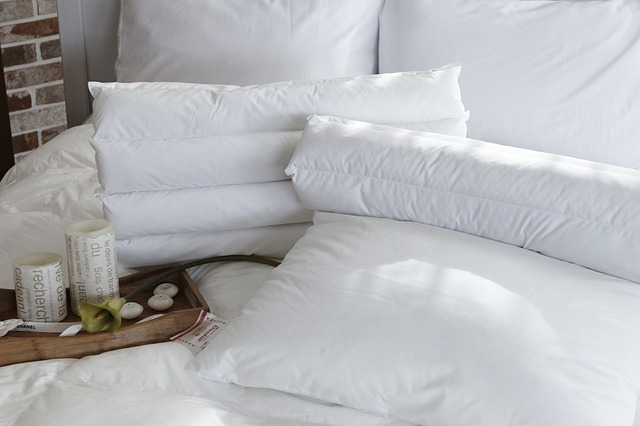 postel s bílými polštáři